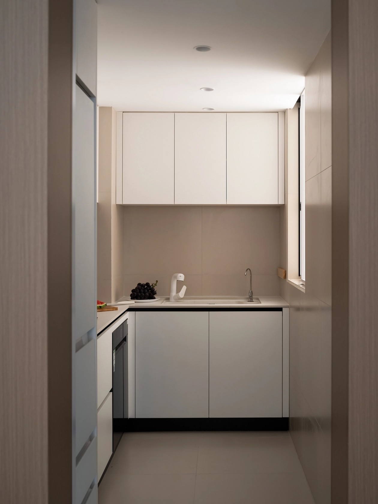Compact white lacquer kitchen with dark countertop