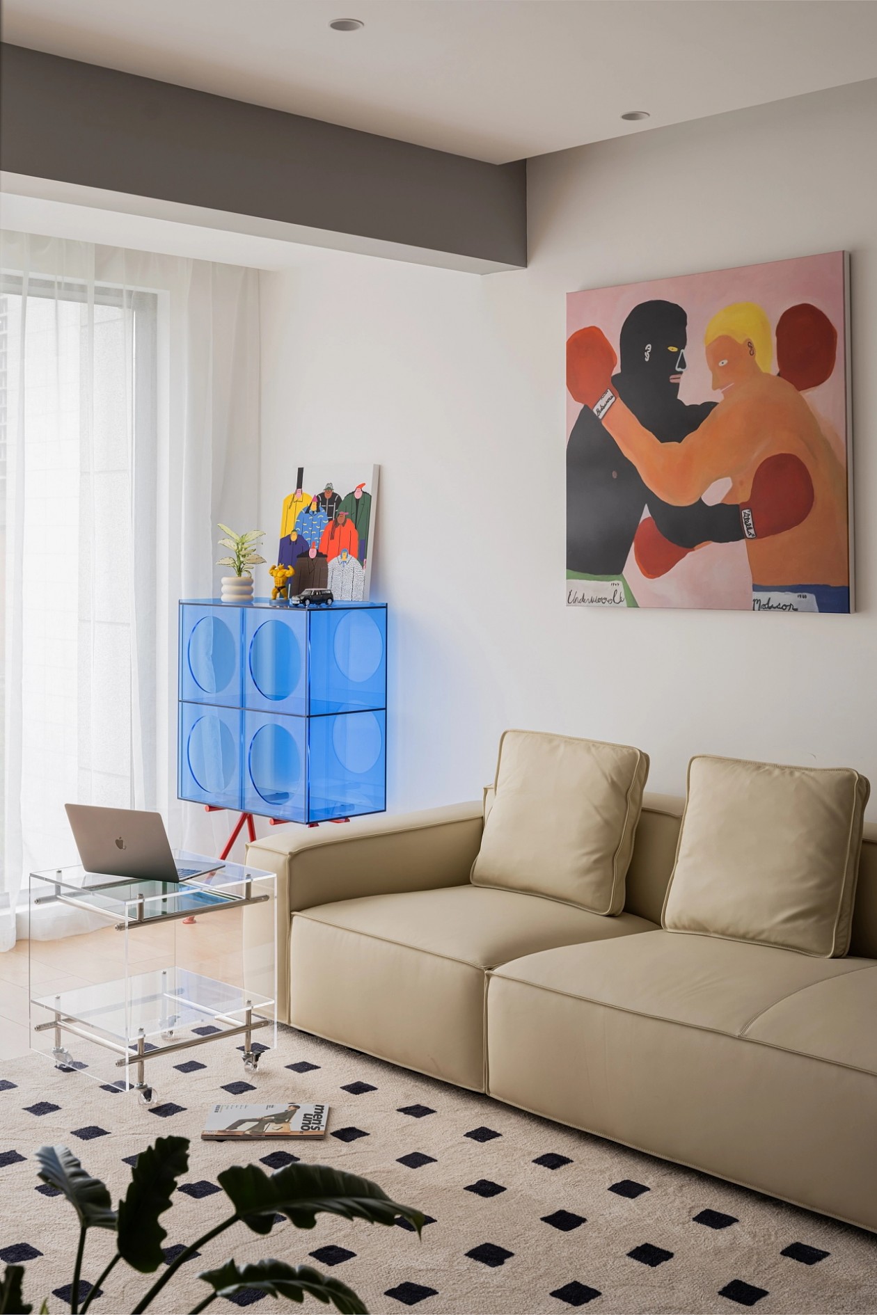 Living room detail with cobalt acrylic storage cabinet and layered artwork