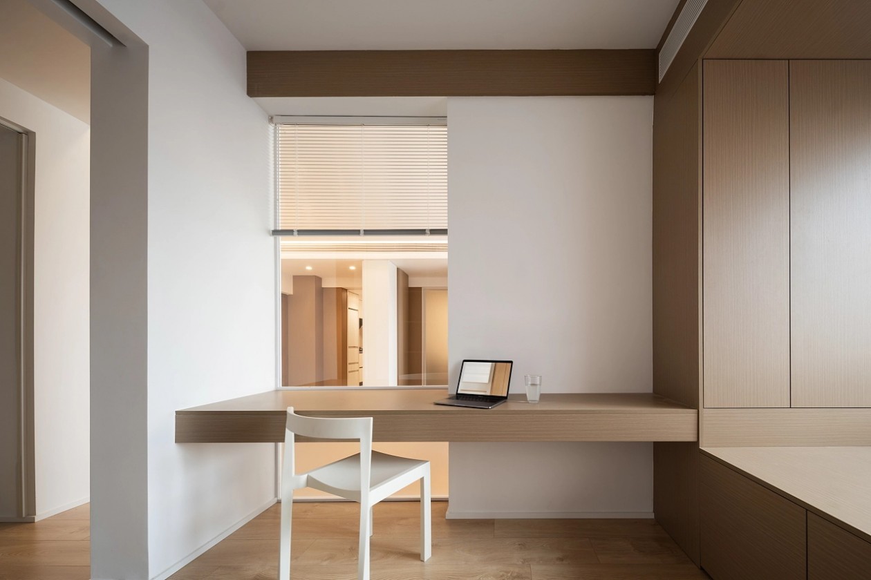 Floating oak desk beneath a window, built into the daybed joinery