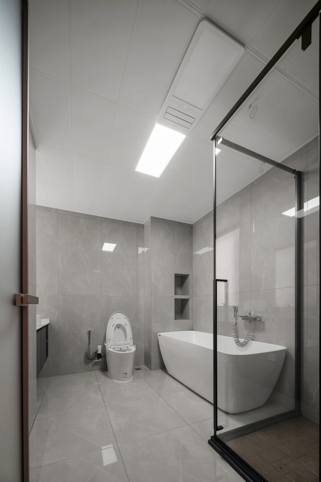 Ensuite bathroom with freestanding tub and grey marble tile