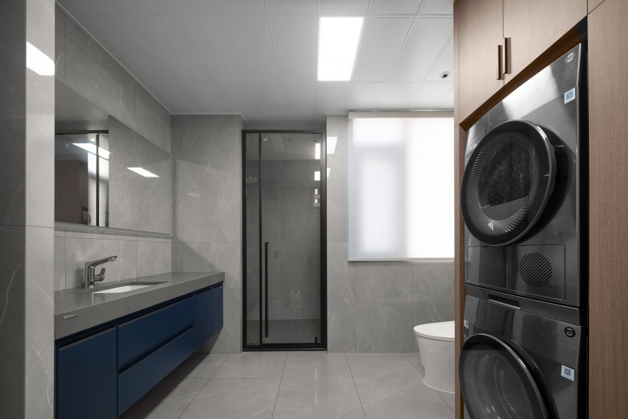 Bathroom with cobalt blue vanity and built-in washer-dryer