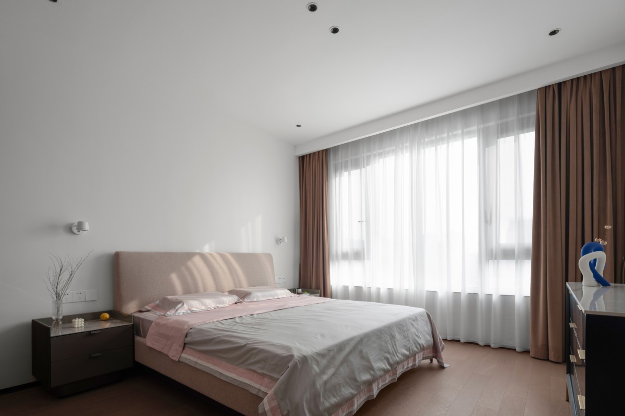 Guest bedroom with blush linens and upholstered headboard