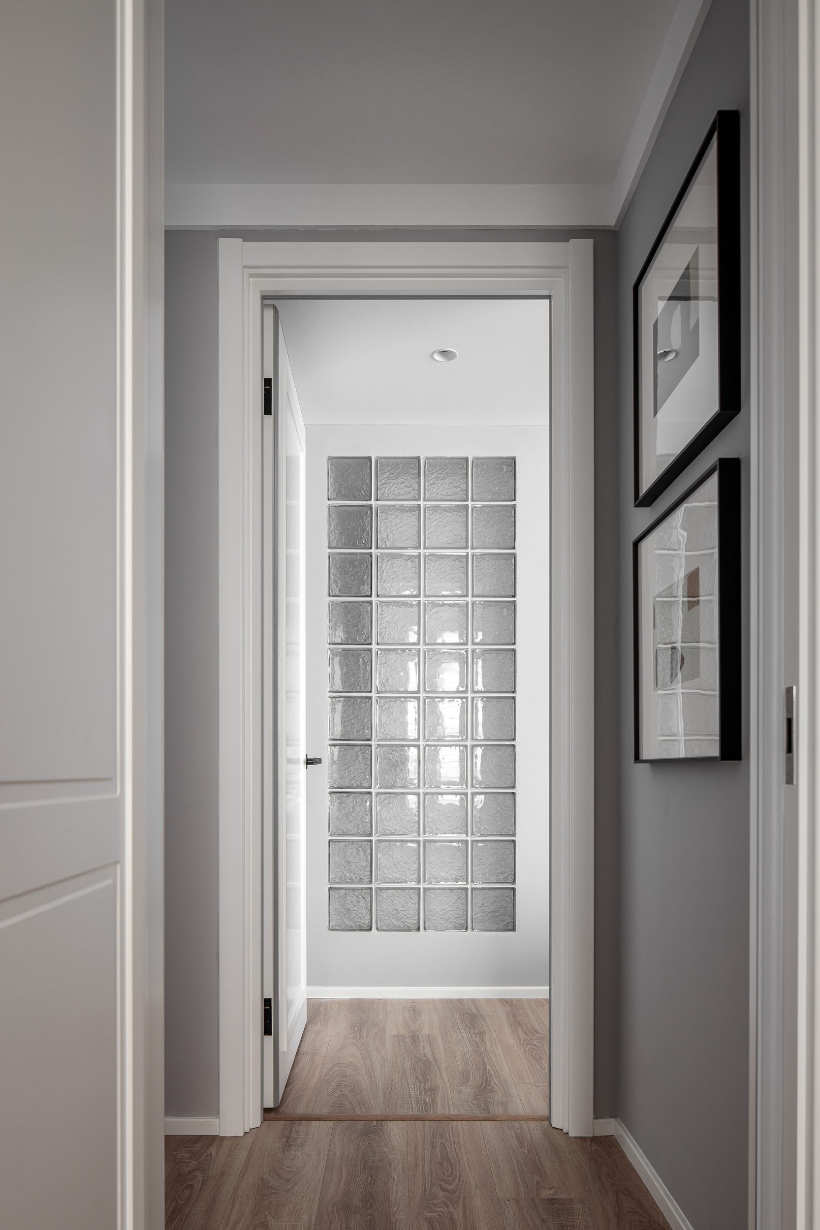 Hallway with glass block partition wall and framed artwork