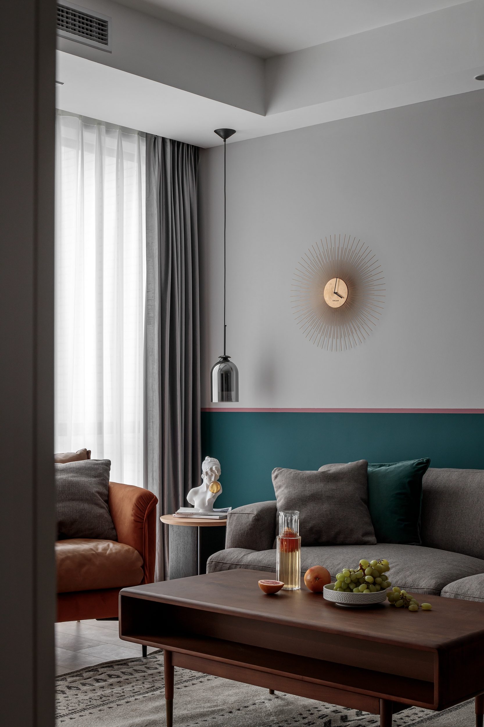 Living room with terracotta leather armchair and teal accent wall