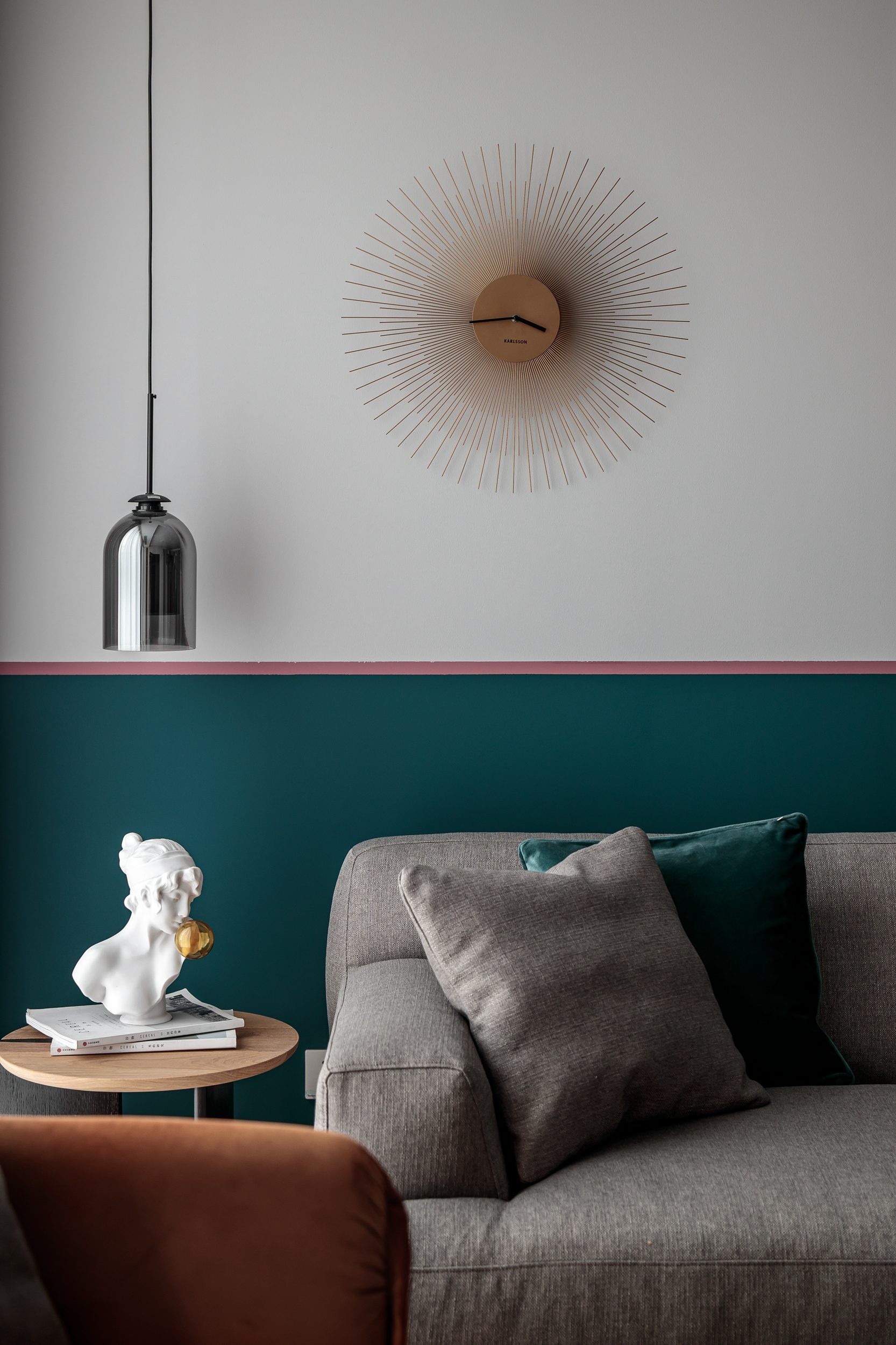 Living room detail with sunburst clock and teal wainscoting