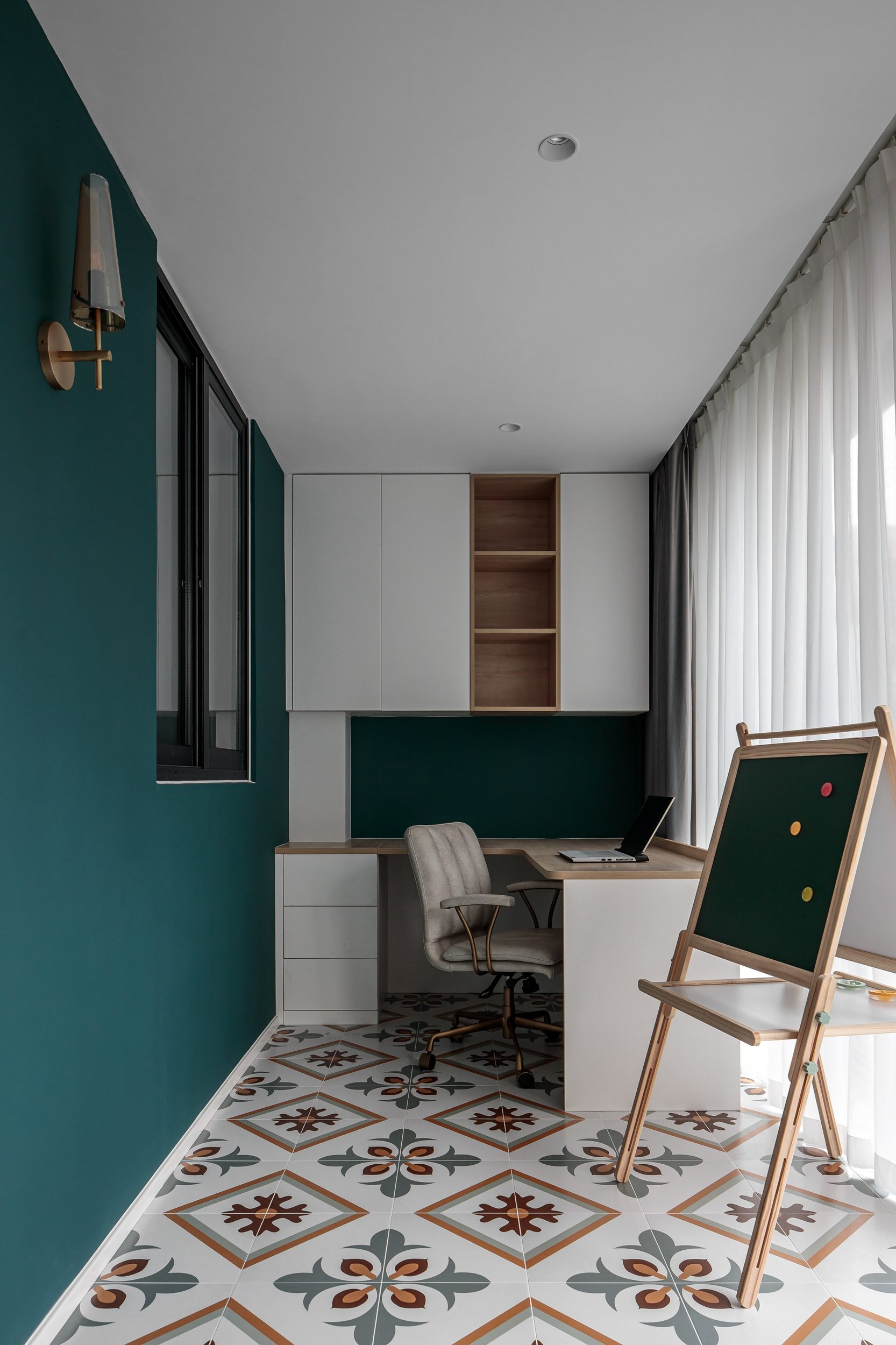 Balcony study nook with teal walls and patterned tile floor
